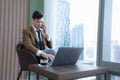 Young businessman sit and relax in the relaxation room by the window overlooking the beautiful city buildings Royalty Free Stock Photo