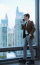 Young businessman sit and relax in the relaxation room by the window overlooking the beautiful city buildings. Royalty Free Stock Photo