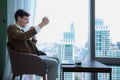 Young businessman sit and relax in the relaxation room by the window overlooking the beautiful city buildings Royalty Free Stock Photo