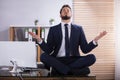 Businessman Doing Yoga In Office Royalty Free Stock Photo