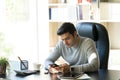 A young businessman sitting at home reading a message from a mobile phone. Work from home Royalty Free Stock Photo