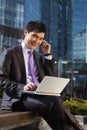 Young businessman sitting with laptop.