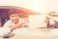 Young businessman sitting in the modern car and holding blank of Royalty Free Stock Photo