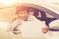 Young businessman sitting in the modern car and holding blank of Royalty Free Stock Photo