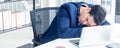 A young businessman sitting in a modern office. He has a feel sleepy because hard work so tired weary fatigued and exhausted. On