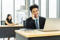 Young businessman sitting at office talking on mobile phone, sitting at desk, using laptop, smiling, businesswoman working Royalty Free Stock Photo