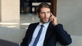 Young businessman sitting relaxed on sofa at hotel lobby making a phone call, waiting for someone. Royalty Free Stock Photo