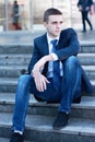 Young businessman sitting on the steps of the office Royalty Free Stock Photo