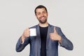 Young businessman with a smile, a man with a beard in a jacket, holding a cup of coffee and showing a thumb up gesture, a man with Royalty Free Stock Photo