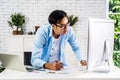 Young businessman smiling happy asian man working on a laptop and writing down ideas in a paperwork at home, work from home Royalty Free Stock Photo