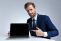 Young businessman smiling and pointing to his laptop Royalty Free Stock Photo