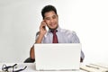 Businessman smiling while talking on the phone and working with laptop computer Royalty Free Stock Photo