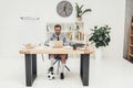 young businessman in soccer shoes with ball under desk Royalty Free Stock Photo