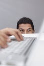 Young businessman spying on someone else`s laptop. Conceptual image