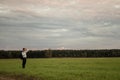 Young businessman standing in green meadow looking in to a distance