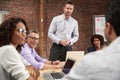 Young Businessman Standing And Leading Office Meeting Around Table Royalty Free Stock Photo