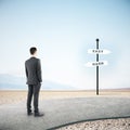 Businessman standing on road and looking on easy and hard sign post