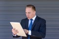 Young businessman staring aghast at his tablet-pc