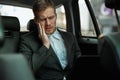 Young businessman suffering extreme toothache while riding on back seat of car showing like sign, looks miserable, healthcare and Royalty Free Stock Photo