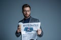 Young businessman in suit and glasses holding a paper cup and business newspaper Royalty Free Stock Photo
