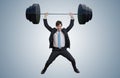Young businessman in suit is lifting heavy weights. Royalty Free Stock Photo
