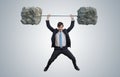 Young businessman in suit is lifting heavy weights. Royalty Free Stock Photo