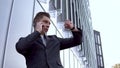 A young businessman in a suit speaks on the phone. Serious man stands in front of a mirror business center Royalty Free Stock Photo