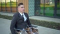 Young businessman in a suit in a wheelchair. A serious man rides in a wheelchair and looks at his watch against the