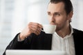 Young businessman takes coffee-break at workplace Royalty Free Stock Photo