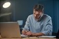 young businessman taking notes in his notebook during night work. Royalty Free Stock Photo