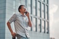 Man on the street. Young businessman talking on cell phone near business center Royalty Free Stock Photo