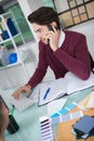 Young businessman talking on mobile phone in office Royalty Free Stock Photo