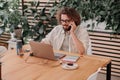 Young businessman talking by phone with client while working on laptop in cozy coworking Royalty Free Stock Photo