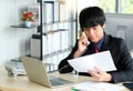 Young businessman is talking on phone with customer. He is working with laptop on the table in the modern office Royalty Free Stock Photo