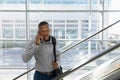 Young businessman talking on phone on an escalator Royalty Free Stock Photo