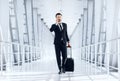 Young businessman talking on phone, walking with luggage in airport Royalty Free Stock Photo