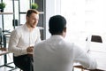 Handsome red-haired businessman talking to African American business partner about new project Royalty Free Stock Photo