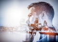 Young businessman thinking. Double exposure city background. Royalty Free Stock Photo