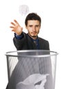 Young businessman throwing paper at trash can Royalty Free Stock Photo