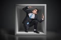 Young businessman trapped inside uncomfortable small box Royalty Free Stock Photo