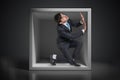 Young businessman trapped inside uncomfortable small box Royalty Free Stock Photo