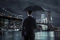 Young businessman with an umbrella over the night city backgroun Royalty Free Stock Photo