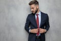 Young businessman unbuttoning his coat smiles and looks down Royalty Free Stock Photo