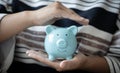 Young businessman uses both hands to protect the piggy bank, Investments or business people working in finance and accounting