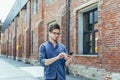 Young businessman uses phone outside office, happy and smiling man with smartphone Royalty Free Stock Photo