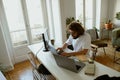 Focused male programmer sitting at desk and working at laptop and computer in home office Royalty Free Stock Photo