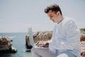 Young businessman using laptop computer on the beach on ocean view background Royalty Free Stock Photo