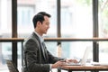 Young Businessman Using Laptop Computer in Modern Office. Manager Thinks About Successful Financial Ideas. Happy Man Royalty Free Stock Photo