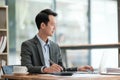 Young Businessman Using Laptop Computer in Modern Office. Manager Thinks About Successful Financial Ideas. Happy Man Royalty Free Stock Photo