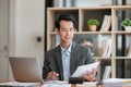 Young Businessman Using Laptop Computer in Modern Office. Manager Thinks About Successful Financial Ideas. Happy Man Royalty Free Stock Photo